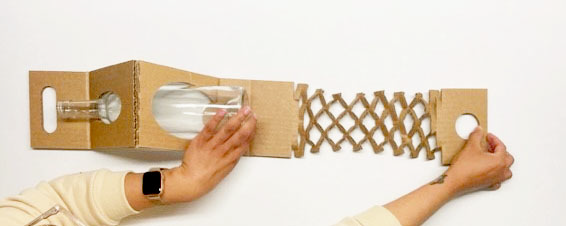 Expandable honeycomb panel being stretched beside a bottle