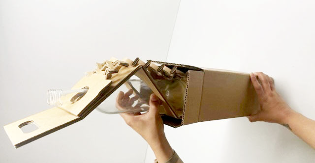 Completed one-bottle protective assembly being inserted into an outer carton